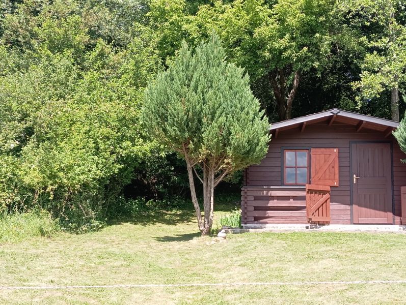 TURANY- rekreačná chata na pozemku 700m2 - Drevená chata obklopená zeleňou na ulici Černík, strom poskytuje prírodný tieň.