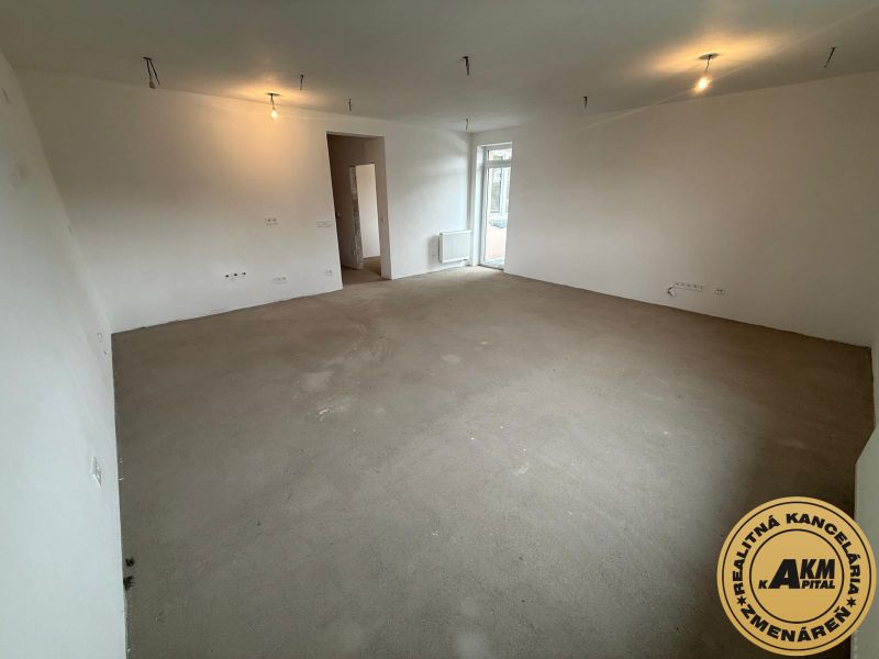 3 izbový byt  75 m2, balkón, novostavba na predaj, Podborová, Zvolen - Veľká prázdna miestnosť v 3-izbovom byte s bielymi stenami a betónovou podlahou.