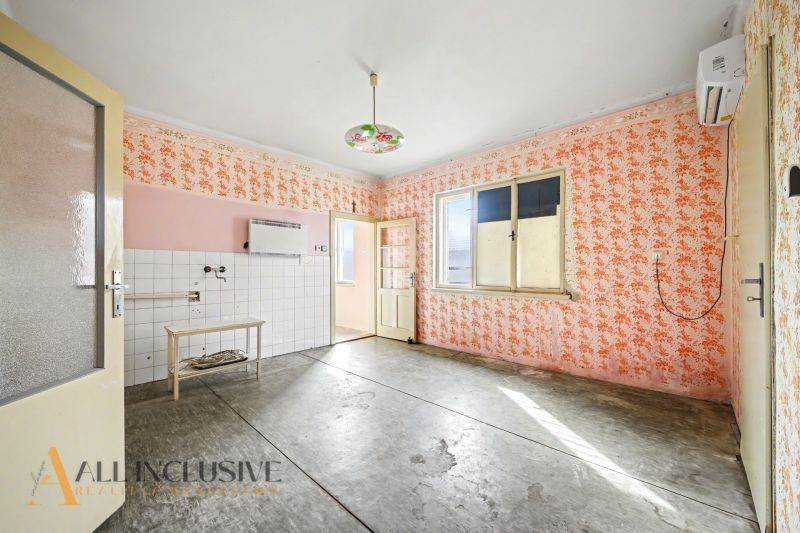 Na predaj 5-izbový rodinný dom, Čierna Voda - Interiér rodinného domu s kvetinovými tapetami, dlaždicovou stenou a stropným svietidlom.