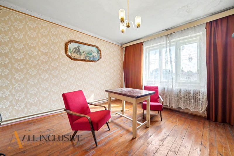 Na predaj 5-izbový rodinný dom, Čierna Voda - Interiér rodinného domu s kvetinovou tapetou, červenými kreslami a podlahou s dreveným dekorom.