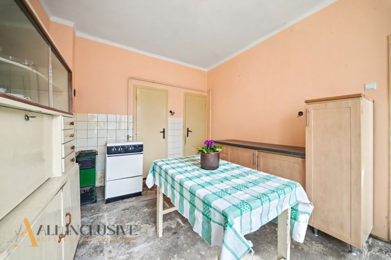 Na predaj 5-izbový rodinný dom, Čierna Voda - Jedáleň v rodinnom dome s kvetinou na stole a skriňami na stenách.