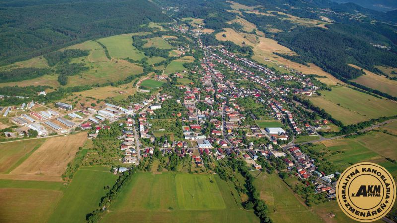 Predaj pozemkov v Badíne (podiely), okres Banská Bystrica  - Letecký pohľad na poľnohospodárske a lesné pozemky v okolí Badína, obklopené domami a budovami.