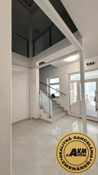 Polyfunkčný priestor v novostavbe,   717 m2 na predaj, Zvolen  - Priestranné obchodné priestory s preskleným balkónom a bielou podlahou.