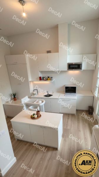 3 izbový byt 86 m2 na predaj,2 balkóny,  novostavba, Zvolen - Kuchyňa v 3-izbovom byte s podlahou s dreveným dekorom, svetlé skrinky a doplnky.