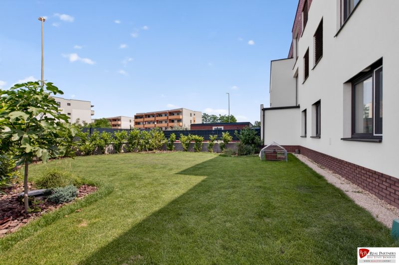 Predaj dizajnový 3-izb byt so záhradou a parkovaním Senec - Záhrada 3-izbového bytu na Vrabčej ulici v Senci s trávnatým pozemkom.