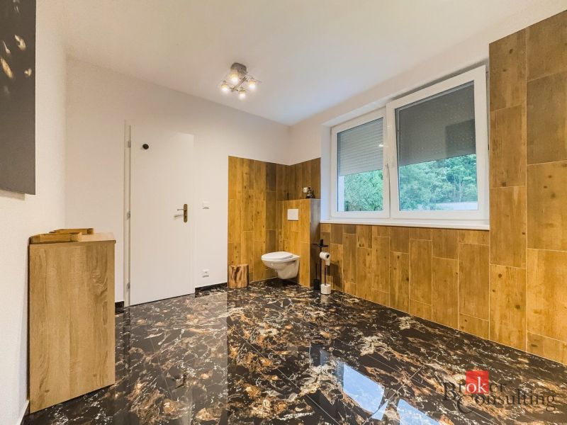 Zariadený 1i apartmán s balkónom na Hradnom kopci - Kúpeľňa s mramorovou podlahou a dreveným dekorom v 1-izbovom byte.