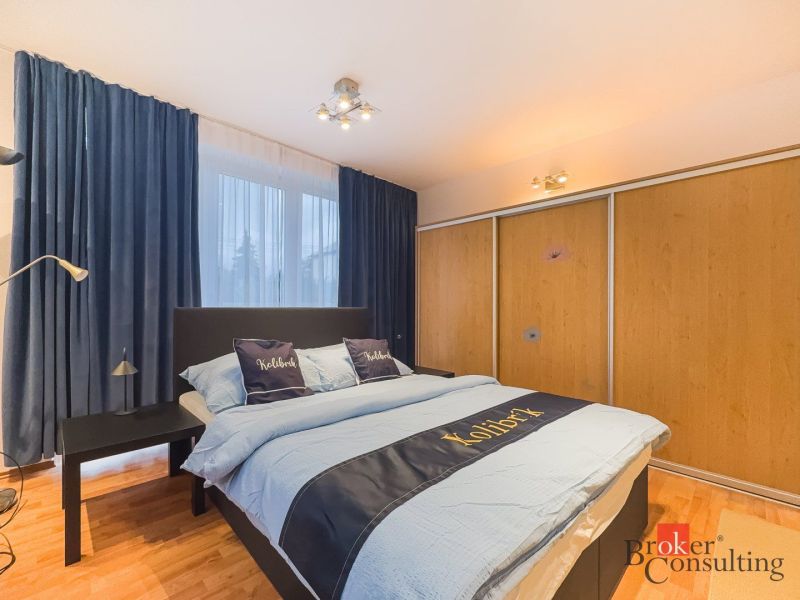 Zariadený 1i apartmán s balkónom na Hradnom kopci - Spálňa v 1-izbovom byte so závesmi, vstavanou skriňou a podlahou s dreveným dekorom.