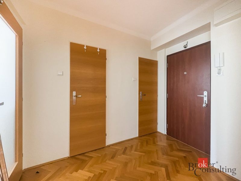 Staromestský 2i byt s balkónom na Palisádach - Vstupná hala v 2-izbovom byte s podlahou s dreveným dekorom, biele steny, tri dvere.