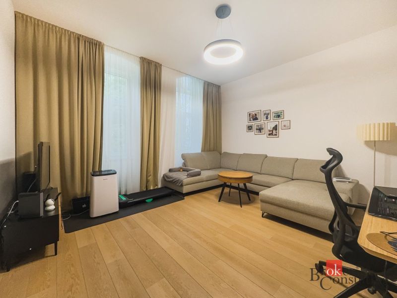 Priestranný petfriendly 2i byt v Starom Meste - Obývacia izba v 2-izbovom byte s pohovkou a podlahou s dreveným dekorom.