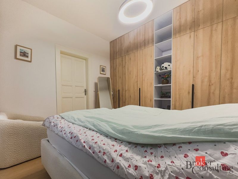 Priestranný petfriendly 2i byt v Starom Meste - Spálňa s veľkou skriňou, posteľou a podlahou s dreveným dekorom v 2-izbovom byte.