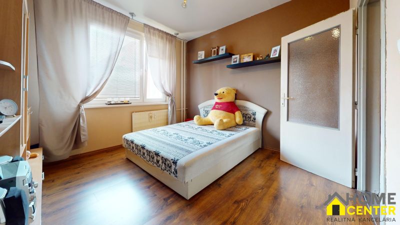 NA PREDAJ 3 IZBOVÝ BYT NA ZAČIATKU VII. SÍDLISKA, UL. PALATÍNOVA - Detská izba v 3-izbovom byte, podlaha s dreveným dekorom, posteľ s hračkou.