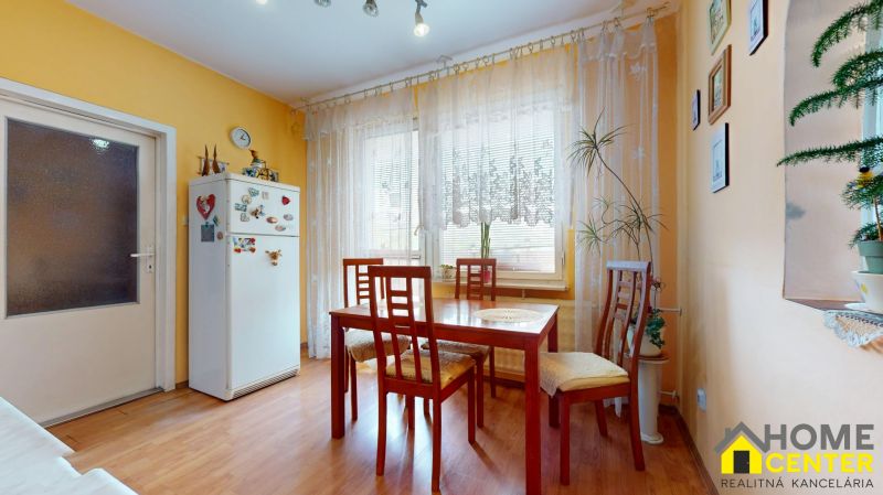 NA PREDAJ 3 IZBOVÝ BYT NA ZAČIATKU VII. SÍDLISKA, UL. PALATÍNOVA - Jedáleň v 3-izbovom byte s podlahou s dreveným dekorom a svetlými záclonami.