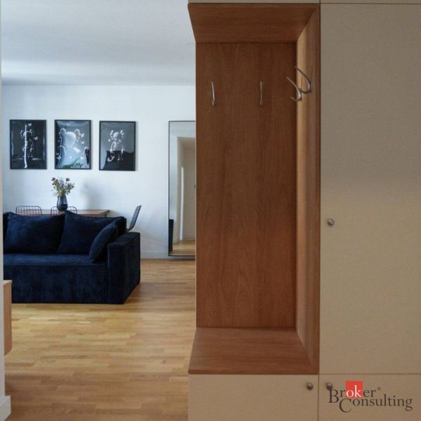 Moderný 2i apartmán v novostavbe v Starom Meste - Interiér 2-izbového bytu s podlahou s dreveným dekorom a tmavým gaučom.