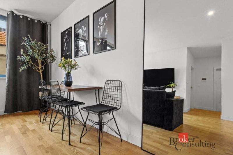Moderný 2i apartmán v novostavbe v Starom Meste - Jedálenský kút s dreveným stolom, kovovými stoličkami a podlahou s dreveným dekorom.