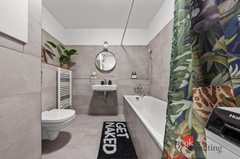 Moderný 2i apartmán v novostavbe v Starom Meste - Kúpeľňa v 2-izbovom byte s vaňou, umývadlom a farebným závesom.