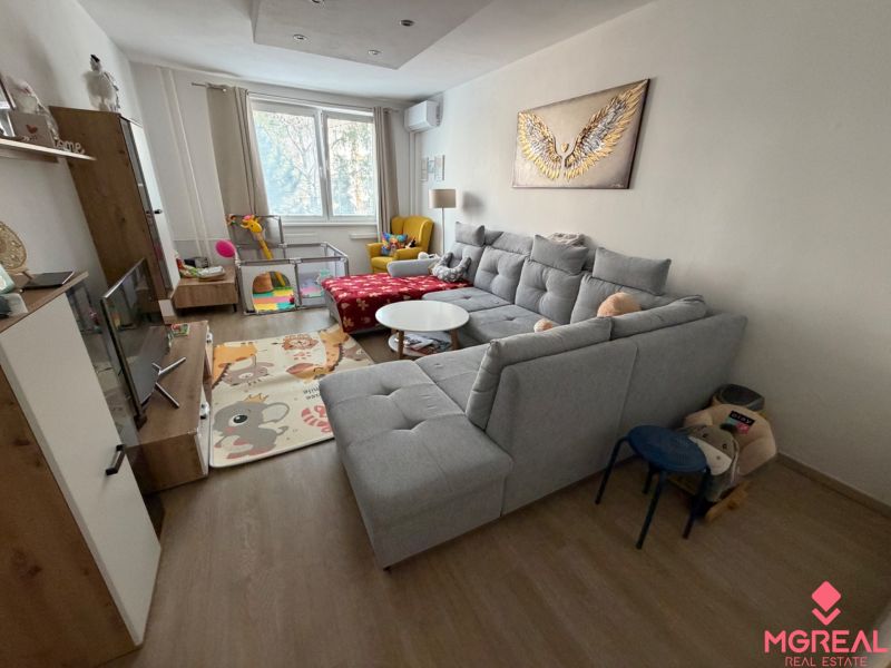 3 izbový byt s balkónom Topoľčany  - Obývačka v 3-izbovom byte s pohodlnou sedačkou a podlahou s dreveným dekorom.