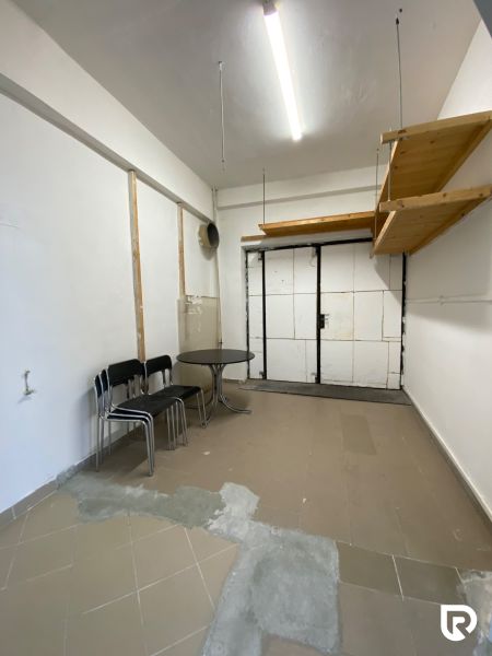 Prenájom 148,25 m² showroom, predajňa | Zlatovce - Obchodné priestory s dvoma stoličkami, stolom a policou na stene, podlaha je dlaždicová.