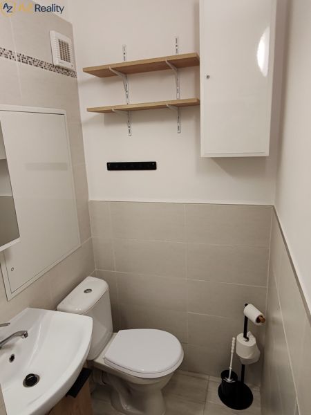 1 izbový byt s balkónom na prenájom  - Kúpeľňa v 1-izbovom byte s umývadlom, toaletu, skrinkami a policami.