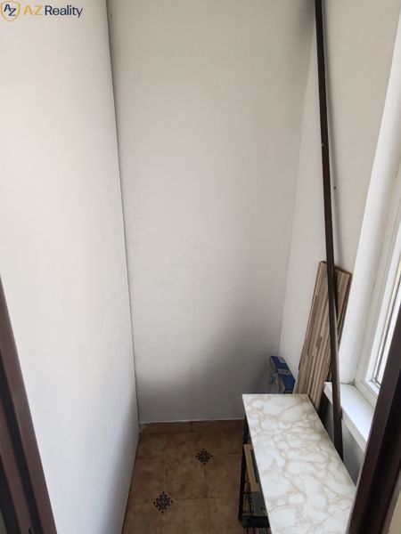 1 izbový byt s balkónom na prenájom  - Úzky priestor v 1-izbovom byte s policou a oknom.