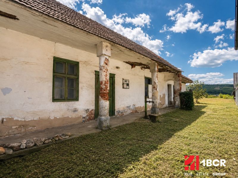 1.BCR | DOM S VEĽKÝM POZEMKOM A POTENCIÁLOM | SOLOŠNICA  - Rodinný dom na ulici Hoštáky v Sološnici so staršími stenami a drevenými oknami.