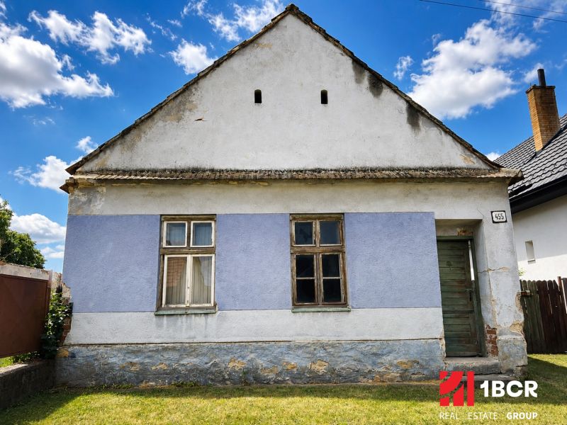 1.BCR | DOM S VEĽKÝM POZEMKOM A POTENCIÁLOM | SOLOŠNICA  - Rodinný dom na ulici Hoštáky v Sološnici s modrou fasádou a starými oknami.