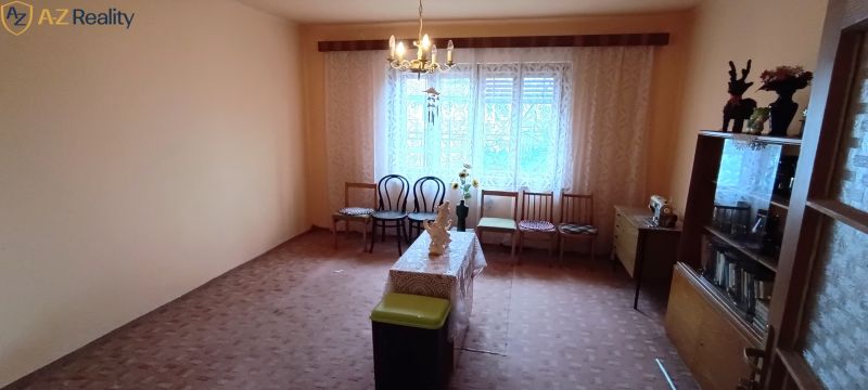 Na predaj starší rodinný dom v meste Nesvady - Obývacia izba v rodinnom dome s jednoduchým zariadením a vintage dekoráciami.