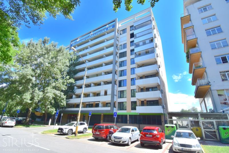 ANTOLSKÁ, 1-i byt  so zimnou záhradou a terasou, 60 m2 – novostavba  - Bytový dom pri Antolskej ulici, Bratislava - Petržalka, s parkoviskom a stromami v okolí.