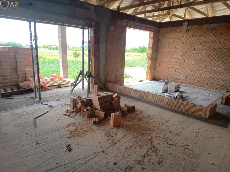 Na predaj novostavba v obci Andovce - Stavba rodinného domu v Andovciach, neukončené steny a stavebný materiál v miestnosti.