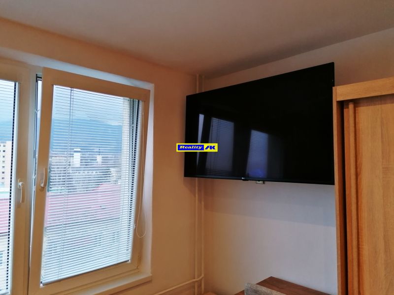 Garsónka na prenájom Vrútky, kompletná rekonštrukcia - Televízor na stene pri okne v garsónke s výhľadom na mesto.