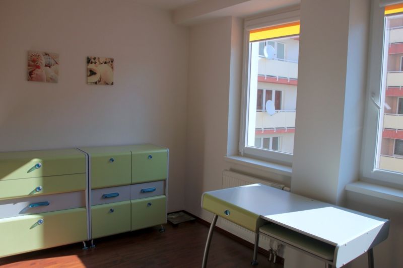 PRENÁJOM: SLNEČNÝ 3 IZBOVÝ BYT S BALKÓNOM A PARKOVANÍM, CENTRUM - Detská izba v 3-izbovom byte s podlahou s dreveným dekorom, zelené skrinky a písací stôl.