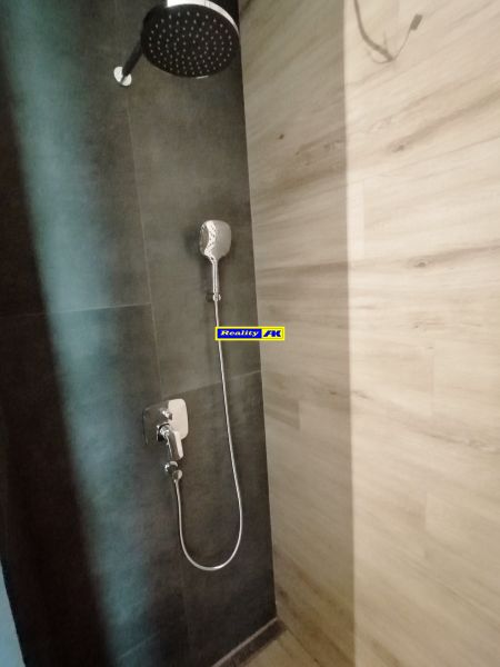 Rodinný dom novostavba na predaj Kláštor pod Znievom  - Sprchový kút s tmavou stenou a podlahou s dreveným dekorom v rodinnom dome.