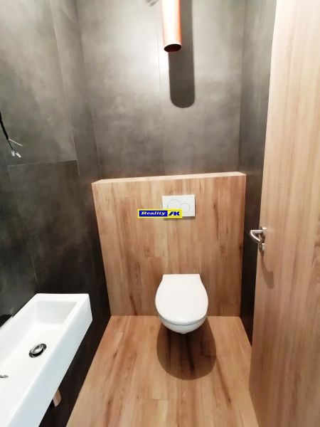 Rodinný dom novostavba na predaj Kláštor pod Znievom  - Kúpeľňa v rodinnom dome s WC a podlahou s dreveným dekorom.