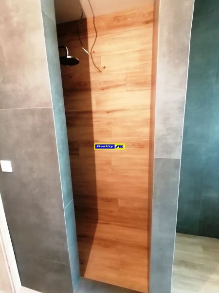 Rodinný dom novostavba na predaj Kláštor pod Znievom  - Sprchový kút s dreveným dekorom a šedými stenami v rodinnom dome.