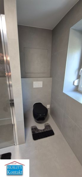 Na prenájom kompletne prerob. NOVÝ 2 izbový byt čiast.zar. Nové Zámky - Kúpeľňa s čiernym WC a sprchovým kútom v 2-izbovom byte, sivé obklady.