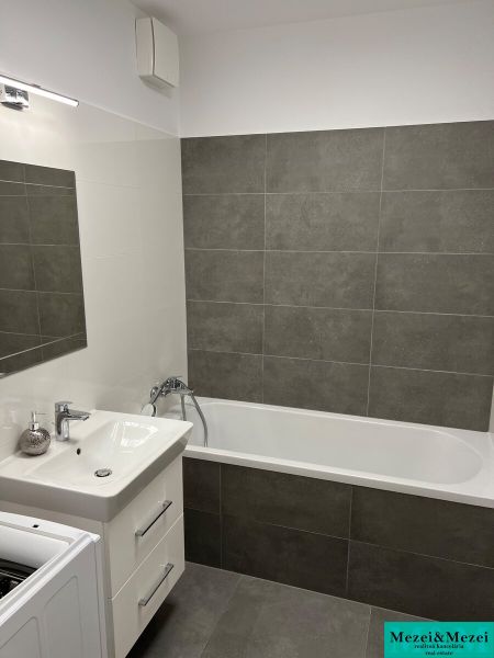 Kompletne zariadený 3-izbový byt s balkónom | PRÚDY Trnava - Kúpeľňa s vaňou a umývadlom, obklady v sivom odtieni v 3-izbovom byte.