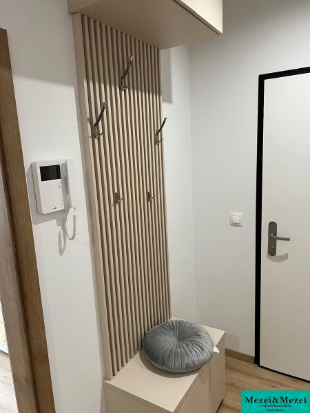 Kompletne zariadený 3-izbový byt s balkónom | PRÚDY Trnava - Chodba s vešiakom a podlahou s dreveným dekorom v 3-izbovom byte.