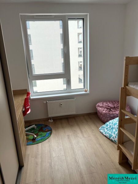 Kompletne zariadený 3-izbový byt s balkónom | PRÚDY Trnava - Detská izba s posteľou a podlahou s dreveným dekorom v 3-izbovom byte.