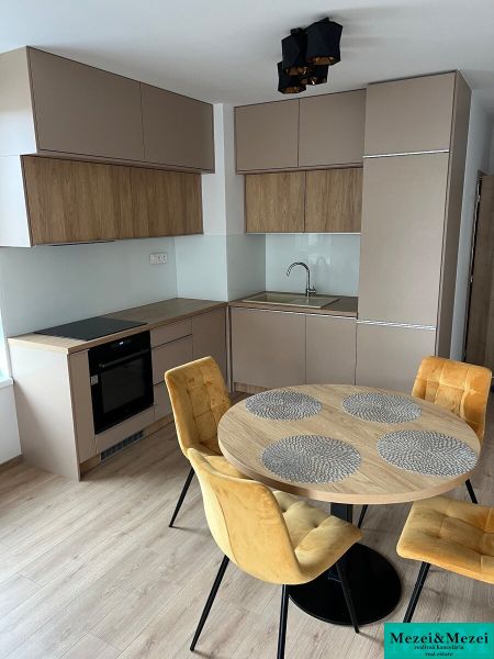 Kompletne zariadený 3-izbový byt s balkónom | PRÚDY Trnava - Kuchyňa v 3-izbovom byte s podlahou s dreveným dekorom a jedálenským stolom.