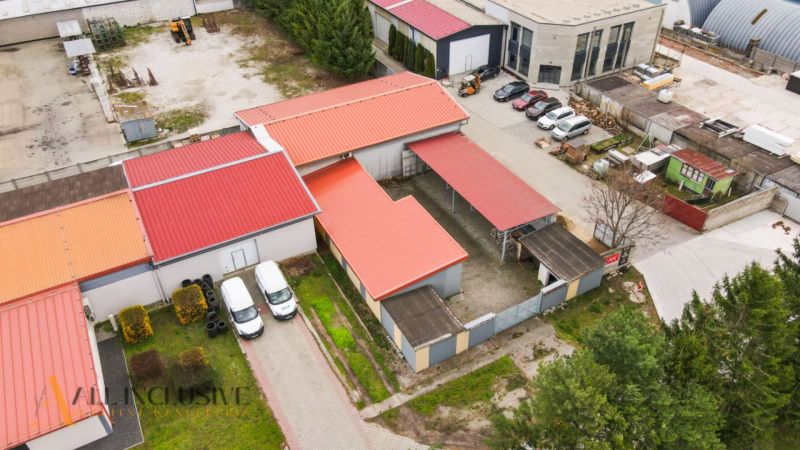 PRAKTICKÉ SKLADOVÉ PRIESTORY  | DOPRAVNÁ | TOPOĽČANY - Priemyselný areál na ulici s halami a skladmi, autá zaparkované v blízkosti budov.