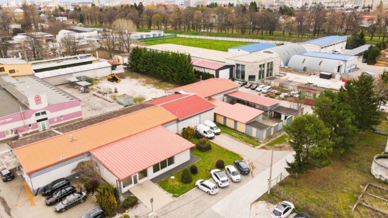 PRAKTICKÉ SKLADOVÉ PRIESTORY  | DOPRAVNÁ | TOPOĽČANY - Oblasť plná budov so skladmi a halami na ulici Dopravná, obklopená zeleňou a parkovaním.