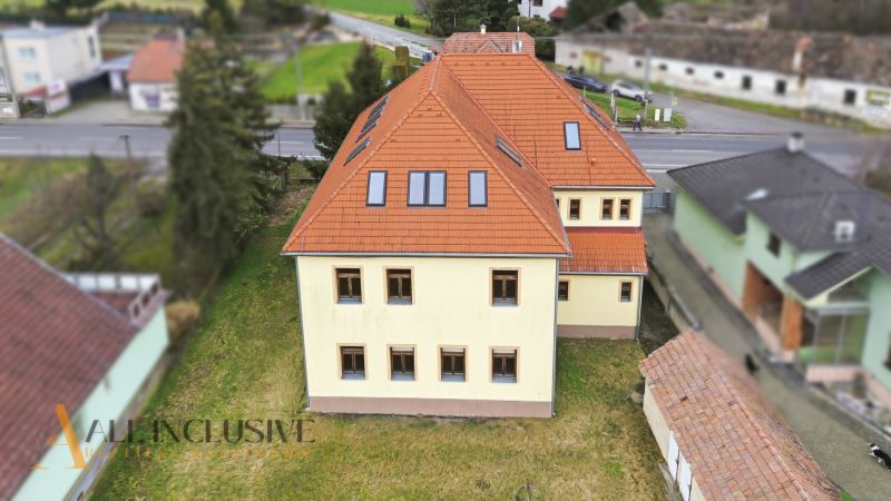  POLYFUNKČNÝ OBJEKT | CHRABRANY | TOPOĽČANY - Budova na ulici Chrabrany v Topoľčanoch má červenú strechu a žltú fasádu.