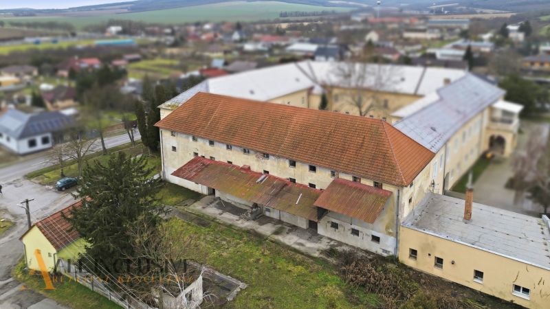 AREÁL | SKLAD | VÝROBNÁ HALA | KOVARCE | TOPOĽČANY - Výrobné priestory na Hlavnej ulici v Kovarciach s viditeľnou strechou a okolím.