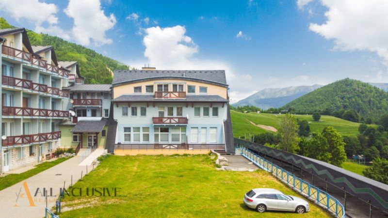 2 IZBOVÝ BYT S PANORAMATICKÝM VÝHĽADOM NA DONOVALY - Apartmánové budovy na Šafránovej ulici v Donovaloch obklopené zeleňou a horami.