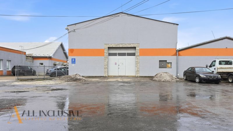 VÝROBNO SKLADOVACIE PRIESTORY | POD KALVÁRIOU  - Budova obchodných priestorov na ulici Pod kalváriou v Topoľčanoch so zaparkovanými autami.