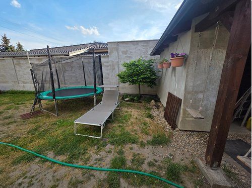 Rodinný dom v obci Malé Leváre  - Záhrada rodinného domu v Malých Levároch s trampolínou a lehátkom.
