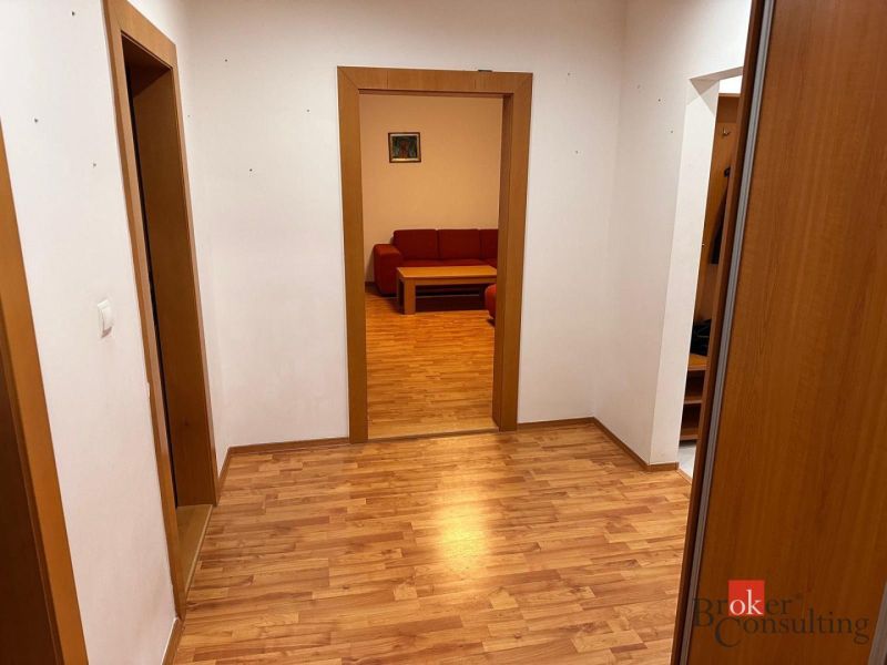 3-izbový byt Prešov, sídl. Sekčov -  REZERVOVANÉ - Chodba v 3-izbovom byte s podlahou s dreveným dekorom a červenou sedačkou.