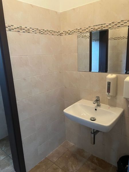 Klimatizovaná 2 - kancelária 25 m2 (12,5 m2 + 12,5 m2) na Pluhovej ul. - Kúpeľňa v kanceláriách s keramickou dlažbou a umývadlom, steny zdobia obkladačky.