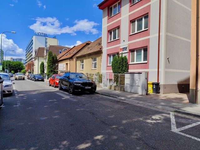 Developerská príležitosť - potenciál výstavby bytových jednotiek - Ulica Líščie nivy v Bratislave zobrazuje rodinné domy s parkovanými autami.