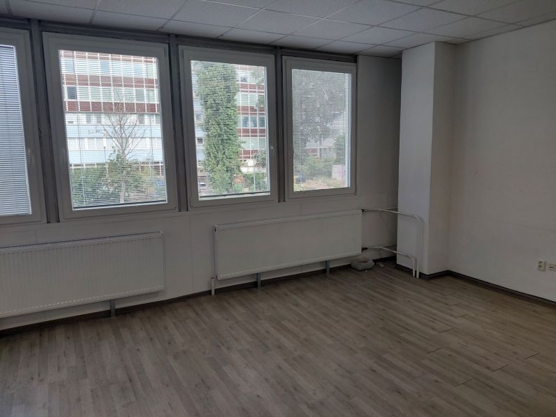 Klimatizovaná kancelária 39 m2 s umývadlom na Tomášikovej ul.  - Kancelárie s veľkými oknami, neutrálne steny, podlaha s dreveným dekorom.