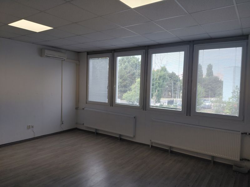 Klimatizovaná kancelária 39 m2 s umývadlom na Tomášikovej ul.  - Prázdna miestnosť s podlahou s dreveným dekorom, oknami a klimatizáciou v Kanceláriách.